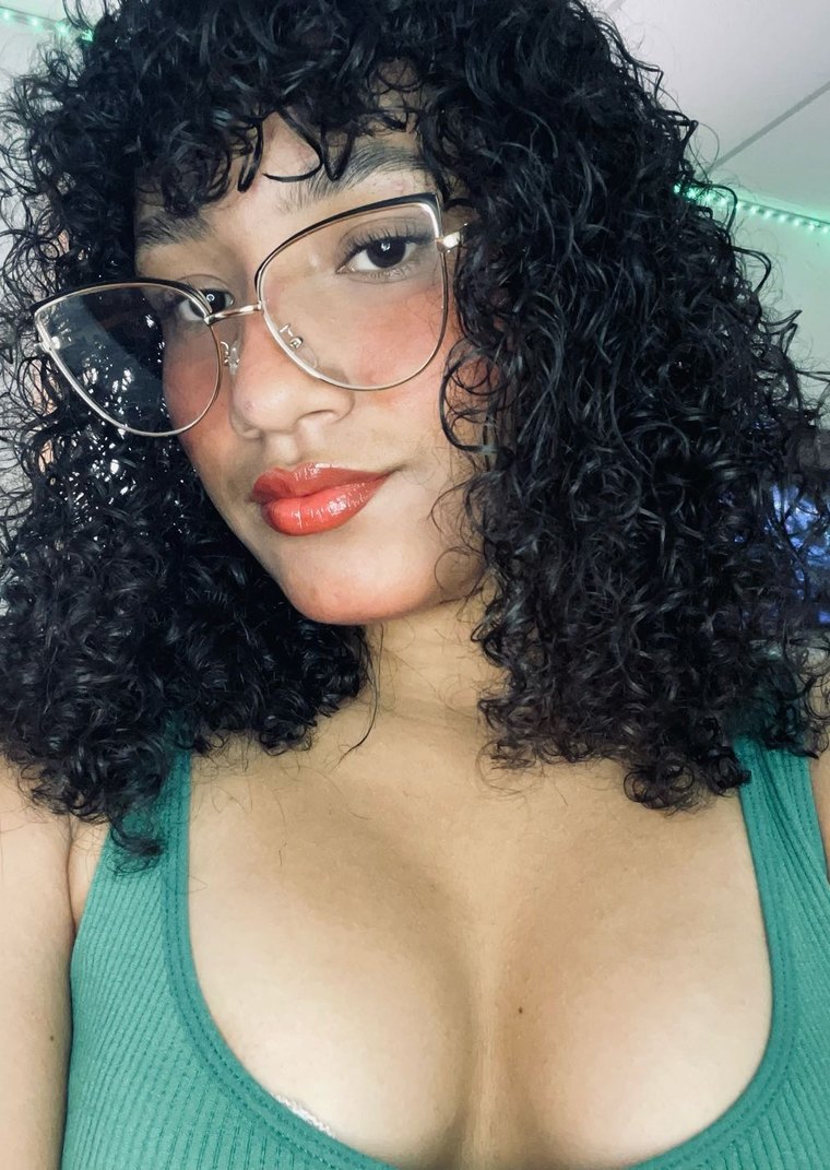 Amor, a Camlace performer with curly hair and glasses